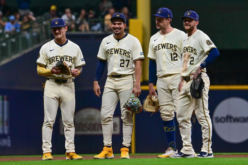 Sep 18, 2024; Milwaukee, Wisconsin, USA;  Milwaukee Brewers third baseman Joseph Ortiz (3), shortstop Willy Adames (27), first baseman Rhys Hoskins (12) and second baseman Brice Turang (2) waits for a pitching change in the sixth inning against the Philadelphia Phillies at American Family Field. Mandatory Credit: Benny Sieu-Imagn Images