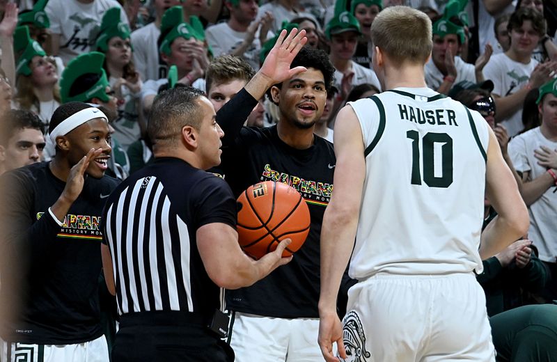 Feb 7, 2023; East Lansing, Michigan, USA; Michigan State Spartans forward Malik Hall (25) high fives forward Joey Hauser (10) from the bench after a play by Hauser in the first half against the Maryland Terrapins at Jack Breslin Student Events Center. Mandatory Credit: Dale Young-USA TODAY Sports