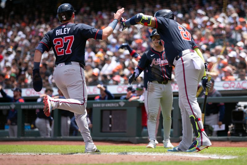 Jun 8, 2025; San Francisco, California, USA; Atlanta Braves third baseman Austin Riley (27) gets a high five from designated hitter Marcell Ozuna (20) as he scores on a Matt Olson double against the San Francisco Giants during the third inning at Oracle Park. Mandatory Credit: D. Ross Cameron-Imagn Images