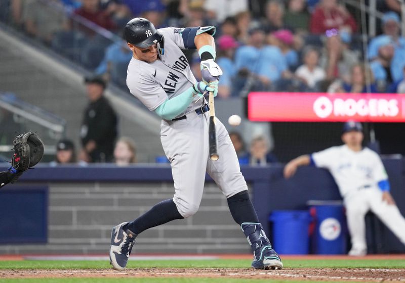 Jun 30, 2024; Toronto, Ontario, CAN; New York Yankees designated hitterAaron Judge (99) hits a broken bat single against the Toronto Blue Jays during the eighth inning at Rogers Centre. Mandatory Credit: Nick Turchiaro-USA TODAY Sports