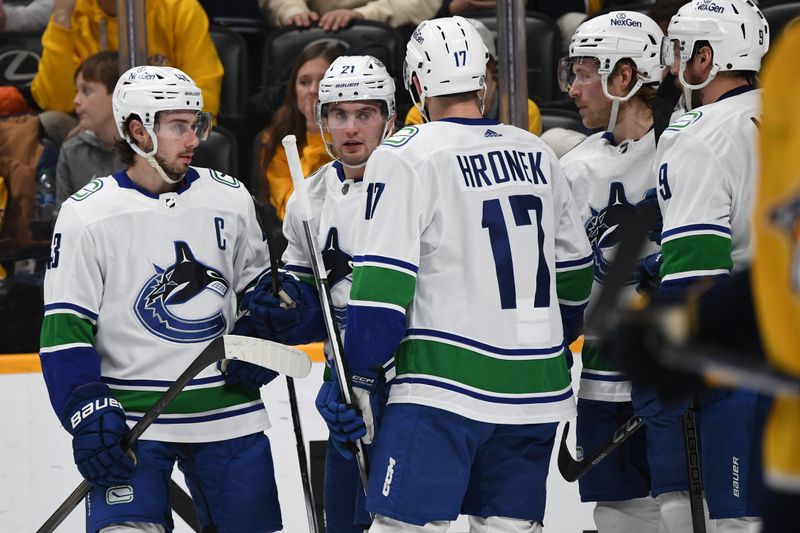 Dec 19, 2023; Nashville, Tennessee, USA; Vancouver Canucks left wing Nils Hoglander (21) celebrates with teammates after a goal during the second period against the Nashville Predators at Bridgestone Arena. Mandatory Credit: Christopher Hanewinckel-USA TODAY Sports