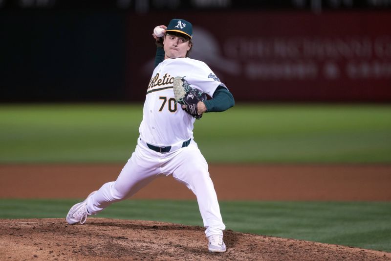 Aug 21, 2024; Oakland, California, USA; Oakland Athletics relief pitcher J.T. Ginn (70) throws a pitch against the Tampa Bay Rays during the eighth inning at Oakland-Alameda County Coliseum. Mandatory Credit: Darren Yamashita-USA TODAY Sports