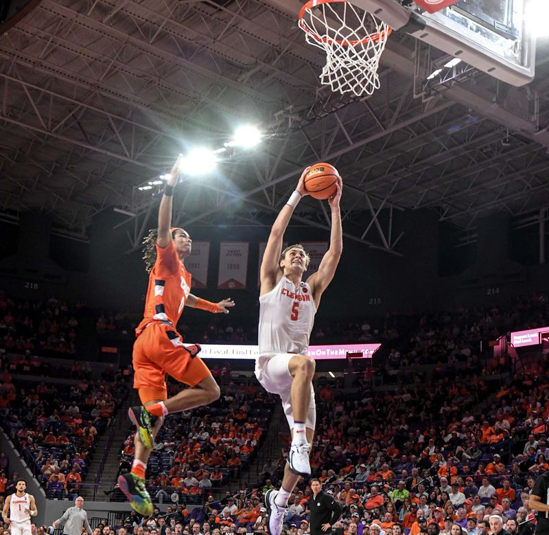 Feb 22, 2023; Clemson, South Carolina, USA; Clemson forward Hunter Tyson (5) dunks against Syracuse forward Chris Bell (0) during the second half at Littlejohn Coliseum. Mandatory Credit: Ken Ruinard-USA TODAY Sports