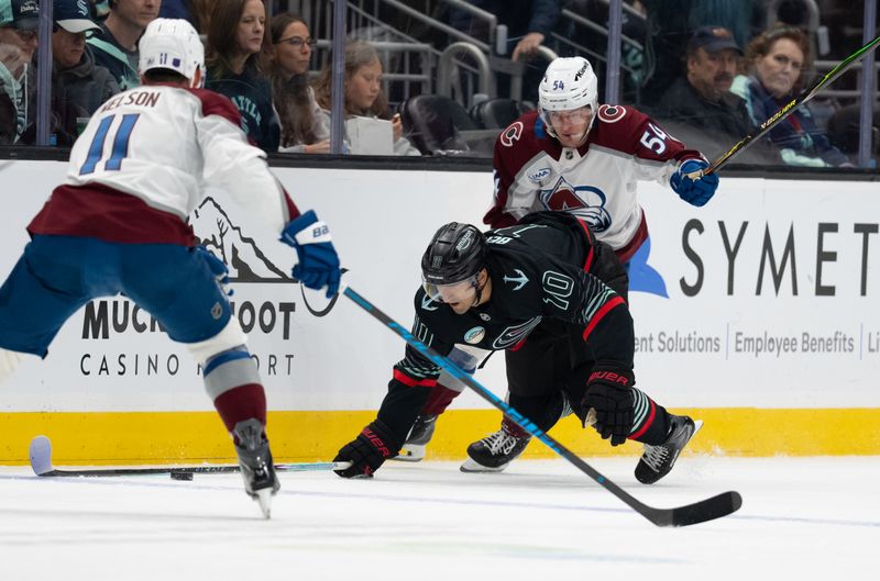 Mar 12, 2026; Seattle, Washington, USA; Seattle Kraken forward Matty Beniers (10) is knocked to the ice by Colorado Avalanche forward Gavin Brindley (54) during the first period at Climate Pledge Arena. Mandatory Credit: Stephen Brashear-Imagn Images