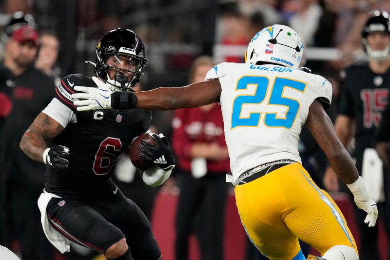 Arizona Cardinals running back James Conner (6) runs from Los Angeles Chargers linebacker Junior Colson (25) during the first half of an NFL football game, Monday, Oct. 21, 2024, in Glendale Ariz. (AP Photo/Matt York)