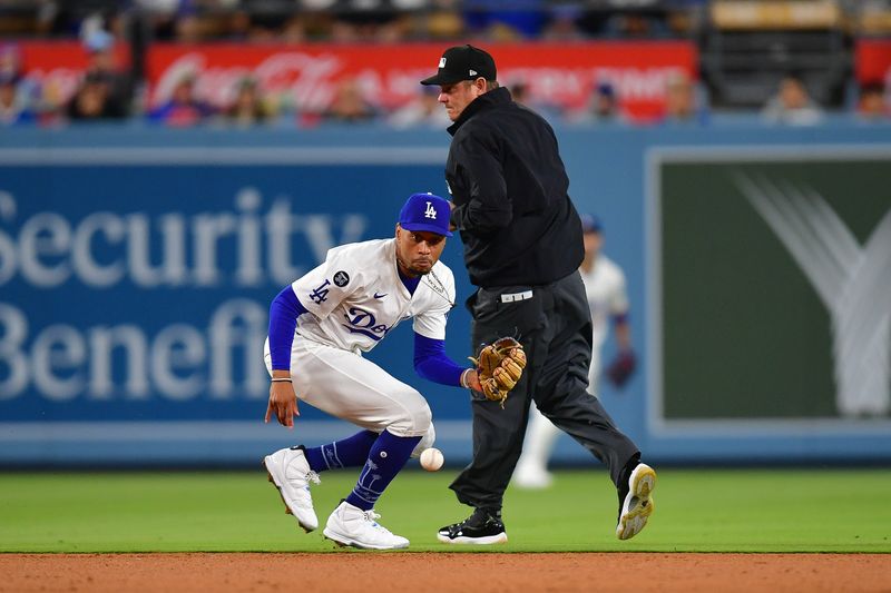 May 19, 2025; Los Angeles, California, USA; Los Angeles Dodgers shortstop Mookie Betts (50) fields the ground ball of Arizona Diamondbacks catcher Gabriel Moreno (14) during the seventh inning at Dodger Stadium. Mandatory Credit: Gary A. Vasquez-Imagn Images