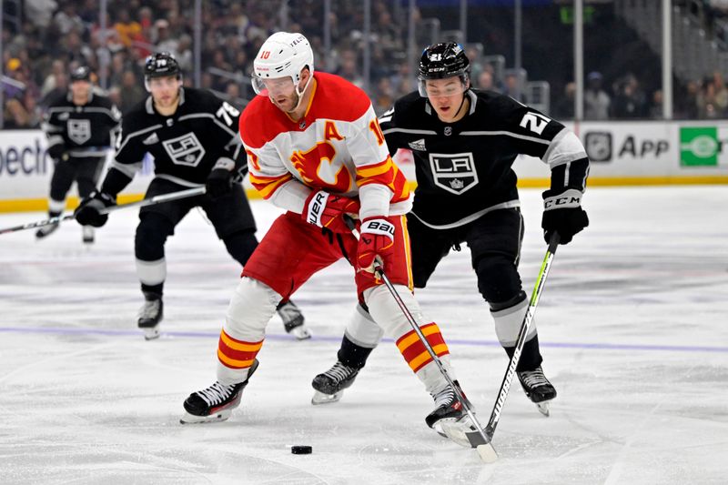 Apr 11, 2024; Los Angeles, California, USA; Los Angeles Kings defenseman Jordan Spence (21) chases down Calgary Flames center Jonathan Huberdeau (10) in the second period at Crypto.com Arena. Mandatory Credit: Jayne Kamin-Oncea-USA TODAY Sports