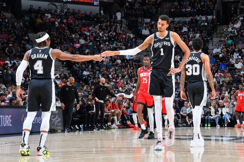 SAN ANTONIO, TX - MARCH 12: Victor Wembanyama #1 of the San Antonio Spurs high fives Devonte Graham #4 during the game against the Houston Rockets on March 12, 2024 at the Frost Bank Center in San Antonio, Texas. NOTE TO USER: User expressly acknowledges and agrees that, by downloading and or using this photograph, user is consenting to the terms and conditions of the Getty Images License Agreement. Mandatory Copyright Notice: Copyright 2024 NBAE (Photos by Michael Gonzales/NBAE via Getty Images)