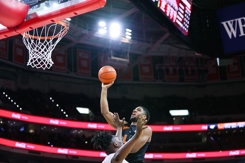 Jan 14, 2023; Raleigh, North Carolina, USA; Miami Hurricanes forward Norchad Omier (15) jumps past North Carolina State Wolfpack forward D.J. Burns Jr. (30) to score a point during the second half against North Carolina State Wolfpack at PNC Arena. Mandatory Credit: Jaylynn Nash-USA TODAY Sports