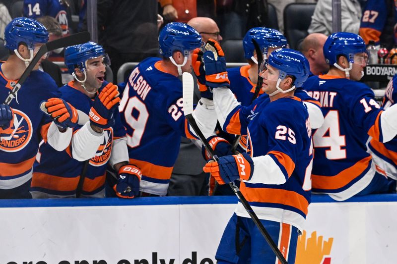 Oct 26, 2024; Elmont, New York, USA;  New York Islanders defenseman Dennis Cholowski (25) celebrates his goal with the New York Islanders bench against the Florida Panthers during the first period at UBS Arena. Mandatory Credit: Dennis Schneidler-Imagn Images