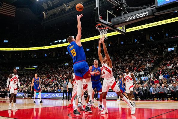 TORONTO, ON - DECEMBER 20: Nikola Jokic #15 of the Denver Nuggets shoots against Scottie Barnes #4 of the Toronto Raptors during the first half at Scotiabank Arena on December 20, 2023 in Toronto, Ontario, Canada. NOTE TO USER: User expressly acknowledges and agrees that, by downloading and/or using this Photograph, user is consenting to the terms and conditions of the Getty Images License Agreement. (Photo by Andrew Lahodynskyj/Getty Images)