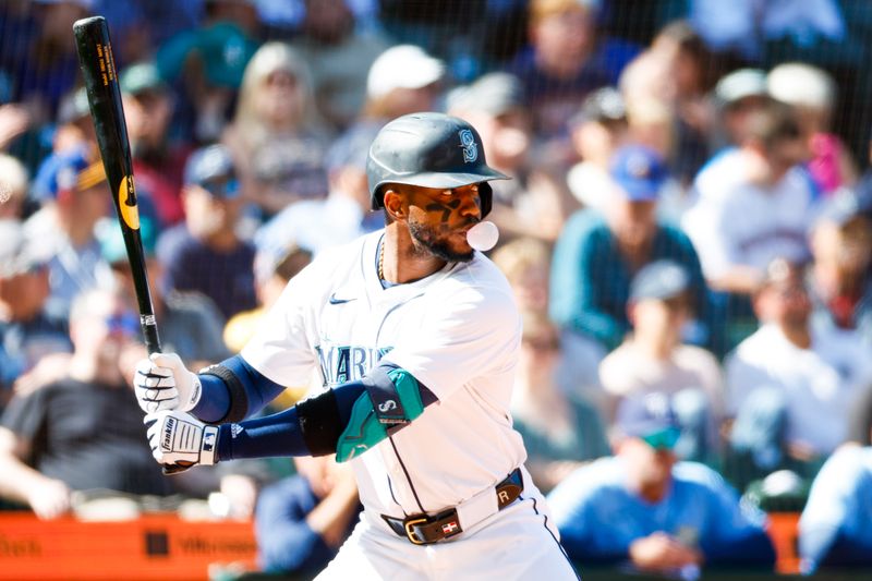 Aug 28, 2024; Seattle, Washington, USA; Seattle Mariners right fielder Victor Robles (10) blows a bubble while taking an at bat against the Tampa Bay Rays during the eighth inning at T-Mobile Park. Mandatory Credit: Joe Nicholson-USA TODAY Sports