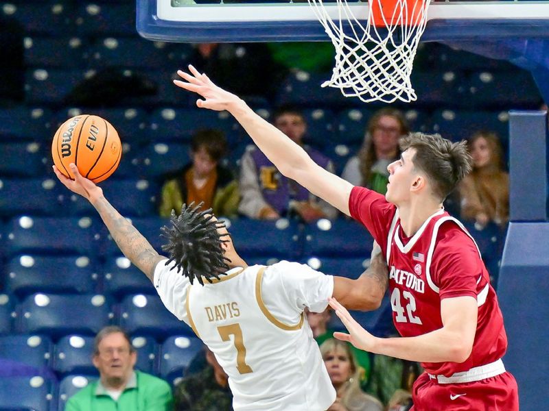 Mar 5, 2025; South Bend, Indiana, USA; Notre Dame Fighting Irish forward Tae Davis (7) goes up for a shot as Stanford Cardinal forward Maxime Raynaud (42) defends in the second half at the Purcell Pavilion. Mandatory Credit: Matt Cashore-Imagn Images