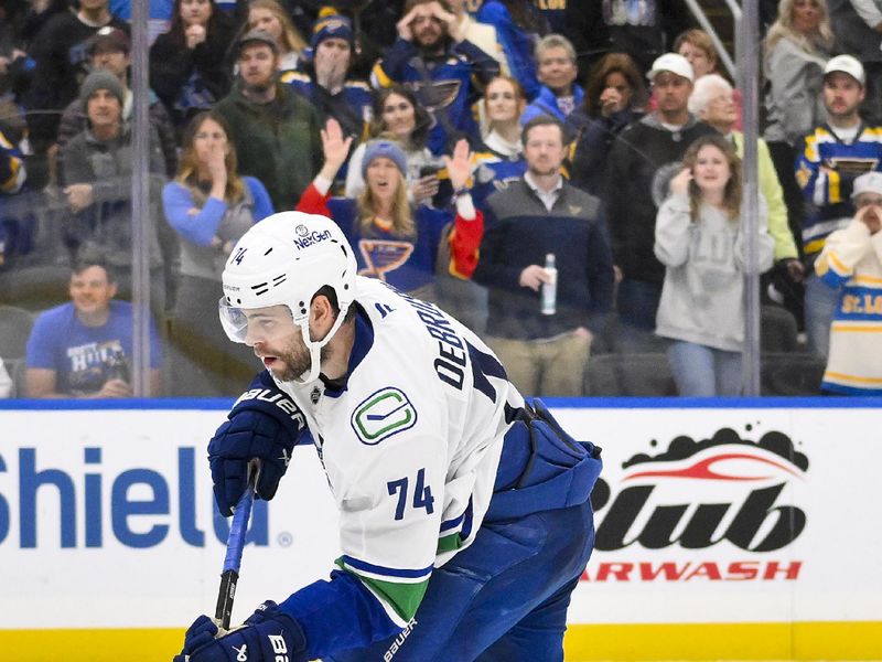 Oct 30, 2025; St. Louis, Missouri, USA; Vancouver Canucks left wing Jake DeBrusk (74) shoots and scores the game winning goal against the St. Louis Blues during shootouts at Enterprise Center. Mandatory Credit: Jeff Curry-Imagn Images