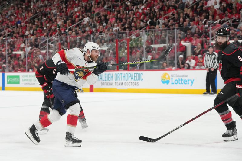 May 20, 2025; Raleigh, North Carolina, USA;  Florida Panthers forward Sam Bennett (9) shoots the puck against Carolina Hurricanes defenseman Brent Burns (8) during the second period in game one of the Eastern Conference Final of the 2025 Stanley Cup Playoffs at Lenovo Center. Mandatory Credit: James Guillory-Imagn Images