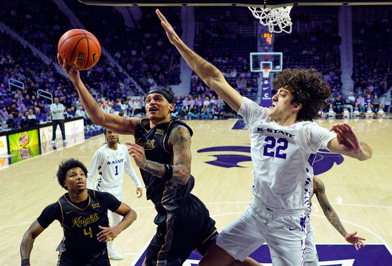 Jan 14, 2026; Manhattan, Kansas, USA; UCF Knights guard Riley Kugel (2) shoots against Kansas State Wildcats center Dorin Buca (22) during the second half at Bramlage Coliseum. Mandatory Credit: Jay Biggerstaff-Imagn Images