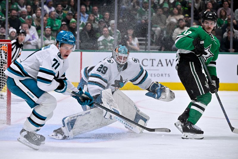 Nov 20, 2024; Dallas, Texas, USA; San Jose Sharks center Macklin Celebrini (71) and goaltender Mackenzie Blackwood (29) and Dallas Stars center Sam Steel (18) look for the puck in the Sharks zone during the second period at the American Airlines Center. Mandatory Credit: Jerome Miron-Imagn Images