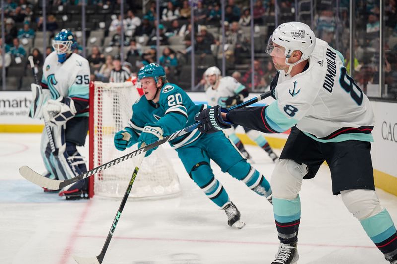 Jan 30, 2024; San Jose, California, USA; Seattle Kraken defenseman Brian Dumoulin (8) plays the puck against San Jose Sharks left wing Fabian Zetterlund (20) during the second period at SAP Center at San Jose. Mandatory Credit: Robert Edwards-USA TODAY Sports