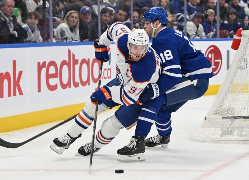 Nov 16, 2024; Toronto, Ontario, CAN;   Edmonton Oilers forward Connor McDavid (97) moves the puck around Toronto Maple Leafs forward Steven Lorentz (18) in the first period at Scotiabank Arena. Mandatory Credit: Dan Hamilton-Imagn Images