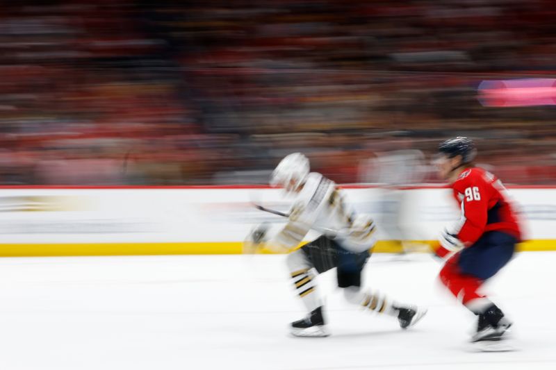 Apr 15, 2024; Washington, District of Columbia, USA; Boston Bruins defenseman Parker Wotherspoon (29) and Washington Capitals right wing Nicolas Aube-Kubel (96) chase the puck in the third period at Capital One Arena. Mandatory Credit: Geoff Burke-USA TODAY Sports