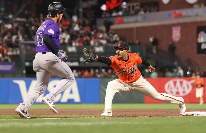 May 2, 2025; San Francisco, California, USA; San Francisco Giants first baseman LaMonte Wade Jr. (31) makes an out against Colorado Rockies designated hitter Hunter Goodman (15) during the sixth inning at Oracle Park. Mandatory Credit: Kelley L Cox-Imagn Images