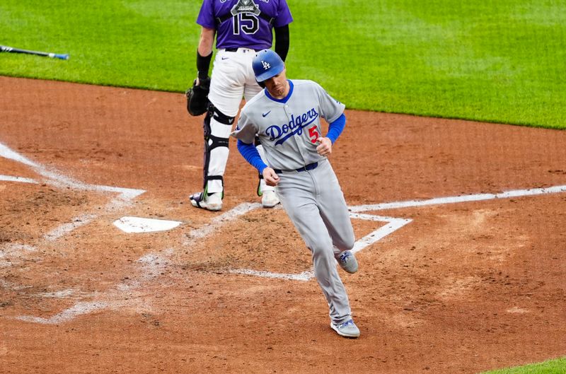 Jun 24, 2025; Denver, Colorado, USA; Los Angeles Dodgers manager Dave Roberts (30) first baseman Freddie Freeman (5) scores a run in the inning against the Colorado Rockies at Coors Field. Mandatory Credit: Ron Chenoy-Imagn Images