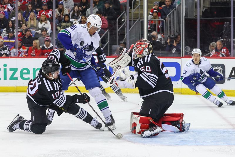 Jan 6, 2024; Newark, New Jersey, USA; New Jersey Devils goaltender Nico Daws (50) makes a save against the Vancouver Canucks during the third period at Prudential Center. Mandatory Credit: Ed Mulholland-USA TODAY Sports