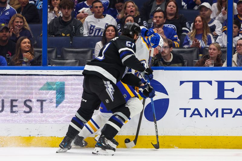 Feb 28, 2026; Tampa, Florida, USA; Buffalo Sabres defenseman Owen Power (25) and Tampa Bay Lightning defenseman Charle-Edouard D'Astous (51) battle for the puck during the second period at Benchmark International Arena. Mandatory Credit: Morgan Tencza-Imagn Images