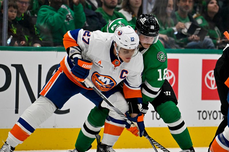 Oct 12, 2024; Dallas, Texas, USA; New York Islanders left wing Anders Lee (27) and Dallas Stars center Sam Steel (18) battle for control of the puck during the second period at the American Airlines Center. Mandatory Credit: Jerome Miron-Imagn Images