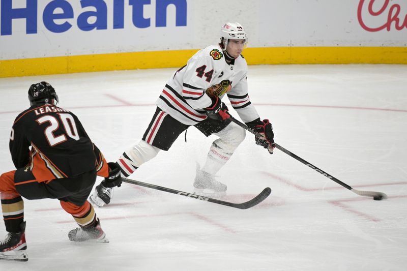 Mar 21, 2024; Anaheim, California, USA; Chicago Blackhawks defenseman Wyatt Kaiser (44) handles the puck in front of Anaheim Ducks right wing Brett Leason (20) in the first period at Honda Center. Mandatory Credit: Jayne Kamin-Oncea-USA TODAY Sports