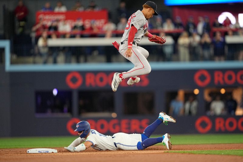 Apr 29, 2025; Toronto, Ontario, CAN; Toronto Blue Jays shortstop Bo Bichette (11) steals second base as Boston Red Sox second baseman Kristian Campbell (28) goes up to catch a ball from Boston Red Sox catcher Carlos Narvaez (not pictured) during the first inning at Rogers Centre. Mandatory Credit: John E. Sokolowski-Imagn Images