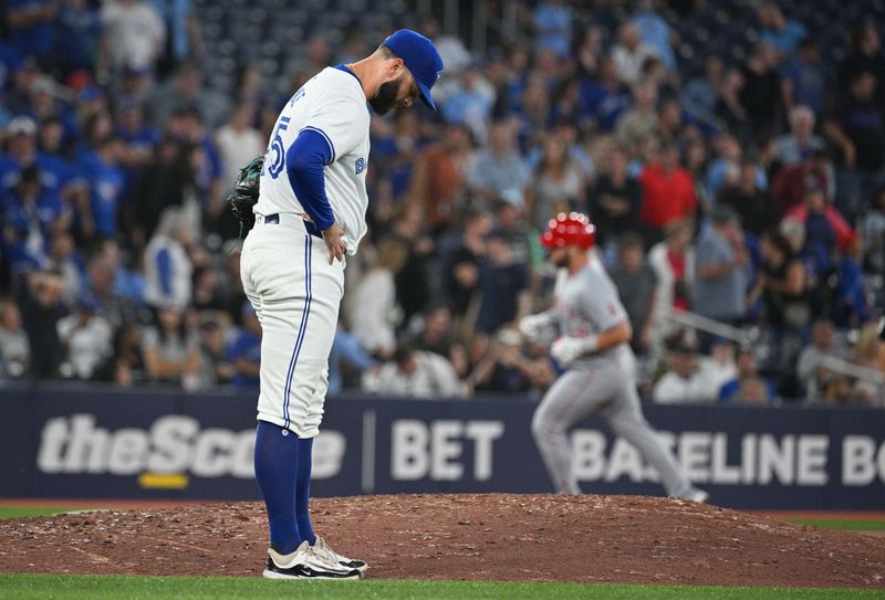 Aug 22, 2024; Toronto, Ontario, CAN;  Toronto Blue Jays relief pitcher Tommy Nance (45) waits to resume play as Los Angeles Angel designated hitter Niko Kavadas (28) rounds the bases after hitting a three run home run in the ninth inning at Rogers Centre. Mandatory Credit: Dan Hamilton-USA TODAY Sports