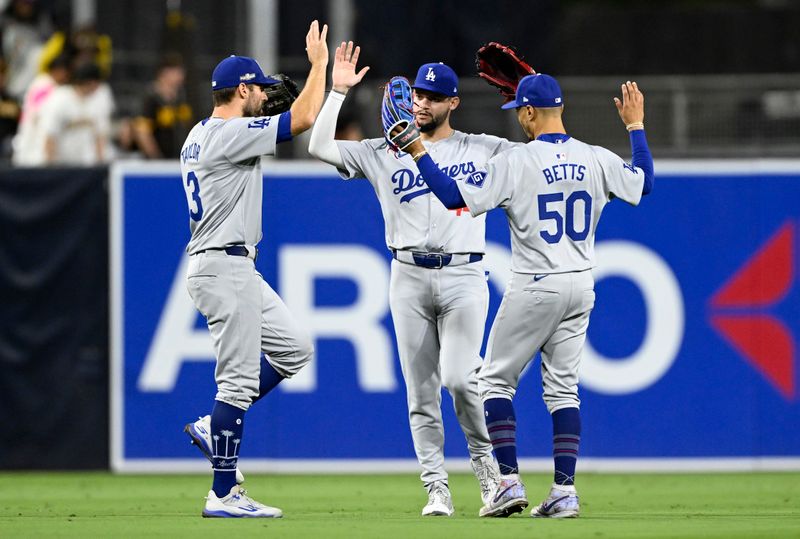 Oct 9, 2024; San Diego, California, USA; Los Angeles Dodgers outfielder Chris Taylor (3), outfielder Andy Pages (44) and shortstop Mookie Betts (50) celebrate after winning game four of the NLDS for the 2024 MLB Playoffs against the San Diego Padres at Petco Park.  Mandatory Credit: Denis Poroy-Imagn Images