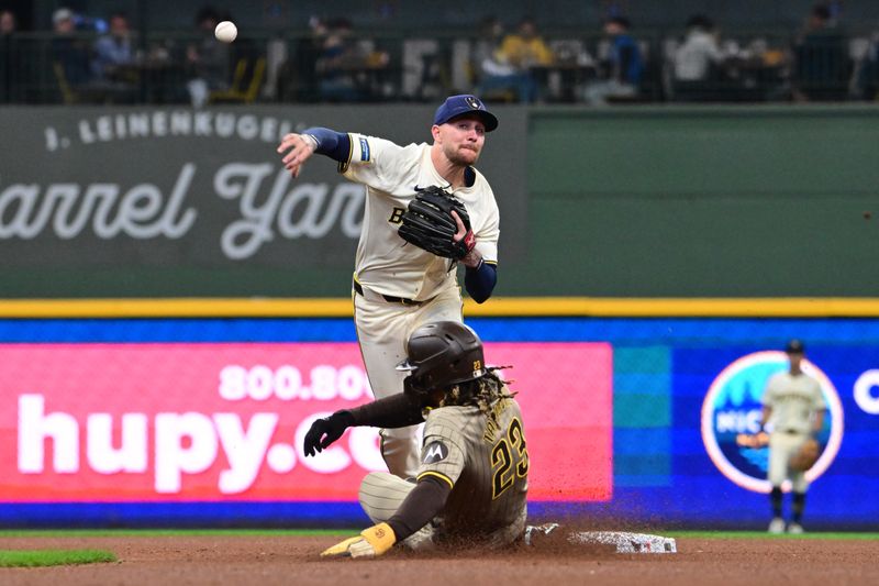 Apr 17, 2024; Milwaukee, Wisconsin, USA;  Milwaukee Brewers second baseman Brice Turang (2) completes a double play after forcing out San Diego Padres right fielder Fernando Tatis (23) in the sixth inning at American Family Field. Mandatory Credit: Benny Sieu-USA TODAY Sports