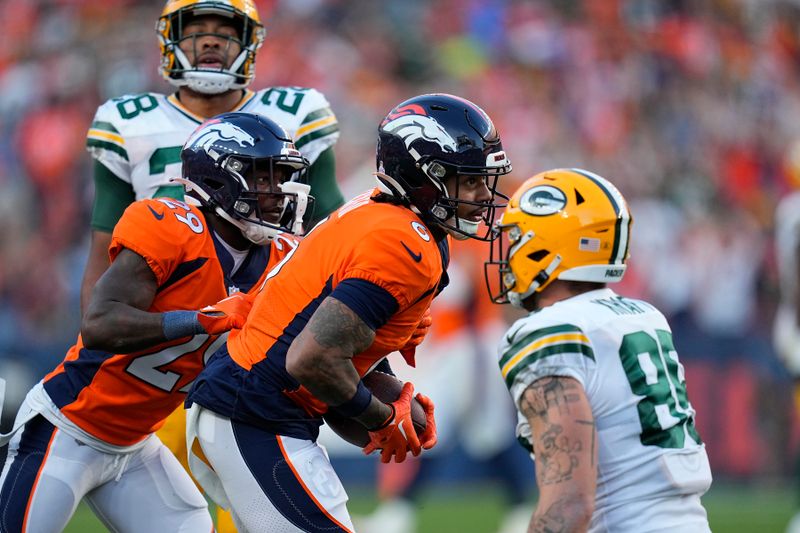 Denver Broncos safety P.J. Locke, middle, reacts after intercepting a pass against the Green Bay Packers during the second half of an NFL football game in Denver, Sunday, Oct. 22, 2023. (AP Photo/Jack Dempsey)