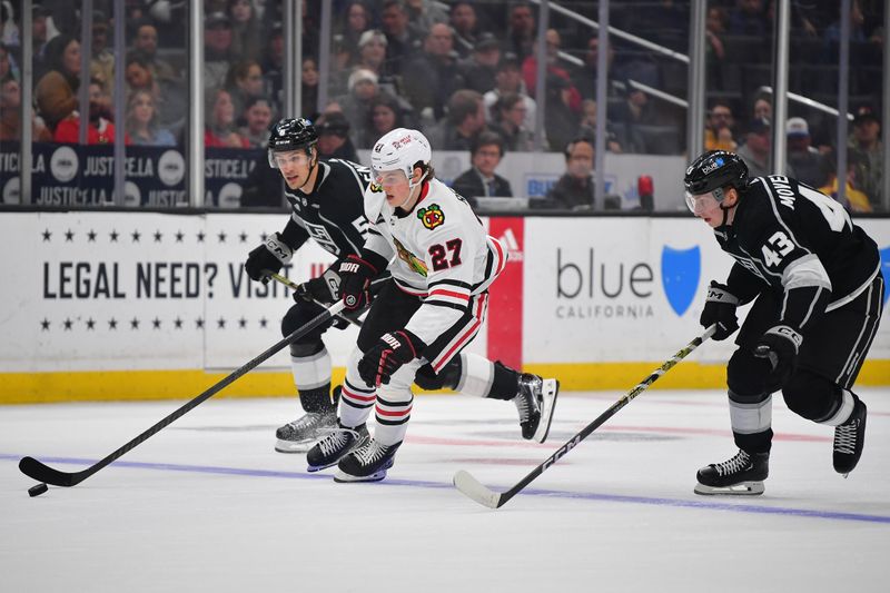 Apr 18, 2024; Los Angeles, California, USA; Chicago Blackhawks left wing Lukas Reichel (27) moves the puck ahead of Los Angeles Kings defenseman Andreas Englund (5) and defenseman Jacob Moverare (43) during the first period at Crypto.com Arena. Mandatory Credit: Gary A. Vasquez-USA TODAY Sports