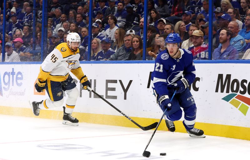 Oct 28, 2024; Tampa, Florida, USA; Tampa Bay Lightning center Brayden Point (21) skates with the puck as Nashville Predators defenseman Alexandre Carrier (45) defends during the first period at Amalie Arena. Mandatory Credit: Kim Klement Neitzel-Imagn Images