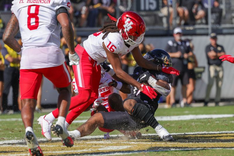 Nov 25, 2023; Orlando, Florida, USA; UCF Knights running back RJ Harvey (7) is tackled by Houston Cougars defensive back Brian George (16) during the second quarter at FBC Mortgage Stadium. Mandatory Credit: Mike Watters-USA TODAY Sports