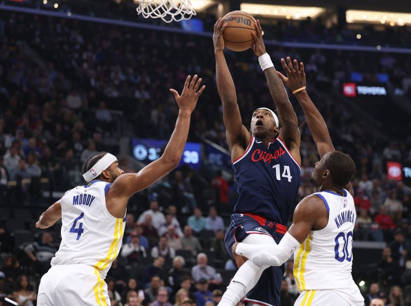 INGLEWOOD, CALIFORNIA - NOVEMBER 18: Terance Mann #14 of the LA Clippers drives to the basket between Moses Moody #4 and Jonathan Kuminga #00 of the Golden State Warriors during the first half at Intuit Dome on November 18, 2024 in Inglewood, California. (Photo by Harry How/Getty Images) NOTE TO USER: User expressly acknowledges and agrees that, by downloading and or using this photograph, User is consenting to the terms and conditions of the Getty Images License Agreement.  (Photo by Harry How/Getty Images)