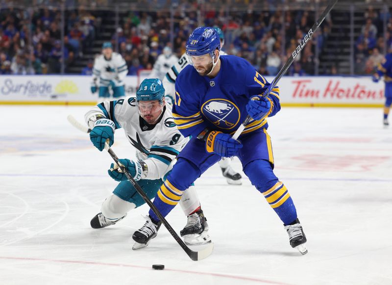 Mar 10, 2026; Buffalo, New York, USA;  San Jose Sharks defenseman Dmitry Orlov (9) tries to knock the puck away from Buffalo Sabres left wing Jason Zucker (17) during the first period at KeyBank Center. Mandatory Credit: Timothy T. Ludwig-Imagn Images