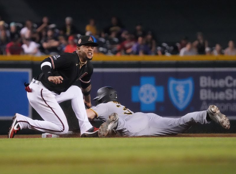 Jul 9, 2023; Phoenix, Arizona, USA;  Arizona Diamondbacks Ketel Marte (4) tags out Pittsburgh Pirates' Henry Davis (32) at second base during their game at Chase Field. Mandatory Credit: Joe Rondone-USA TODAY Sports