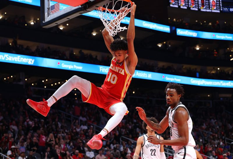 ATLANTA, GEORGIA - OCTOBER 23:  Zaccharie Risacher #10 of the Atlanta Hawks dunks against Ben Simmons #10 of the Brooklyn Nets during the third quarter at State Farm Arena on October 23, 2024 in Atlanta, Georgia.  NOTE TO USER: User expressly acknowledges and agrees that, by downloading and/or using this photograph, user is consenting to the terms and conditions of the Getty Images License Agreement.  (Photo by Kevin C. Cox/Getty Images)