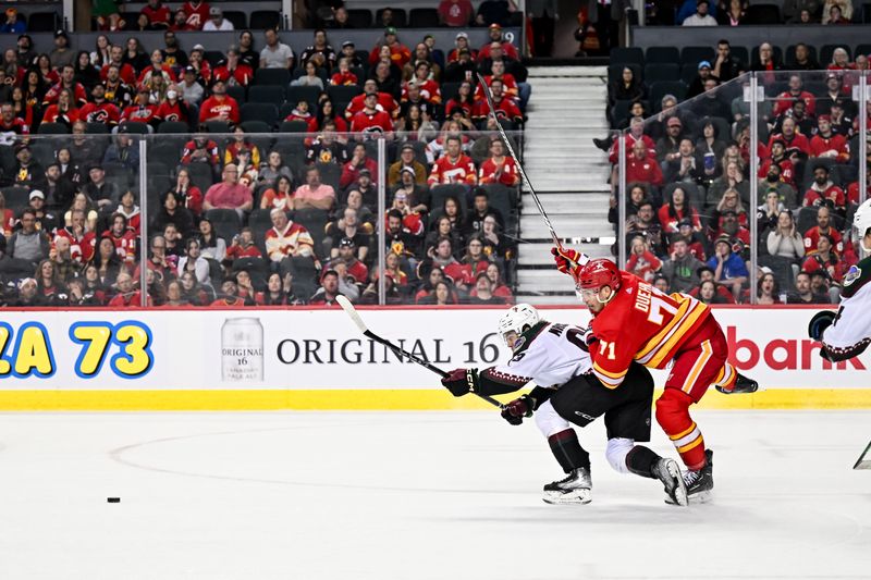 Apr 14, 2024; Calgary, Alberta, CAN; Arizona Coyotes left wing Matias Maccelli (63) and Calgary Flames right wing Walker Duehr (71) compete for the puck during the third period at Scotiabank Saddledome. Mandatory Credit: Brett Holmes-USA TODAY Sports