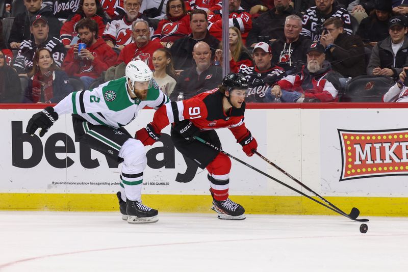 Jan 20, 2024; Newark, New Jersey, USA; New Jersey Devils center Dawson Mercer (91) skates with the puck while being defended by Dallas Stars defenseman Jani Hakanpaa (2) during the second period at Prudential Center. Mandatory Credit: Ed Mulholland-USA TODAY Sports