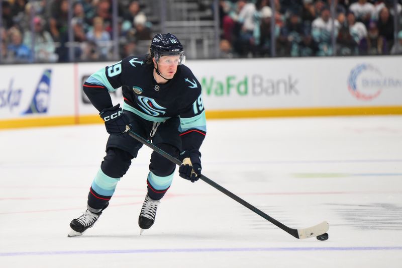 Oct 26, 2024; Seattle, Washington, USA; Seattle Kraken left wing Jared McCann (19) advances the puck against the Carolina Hurricanes during the first period at Climate Pledge Arena. Mandatory Credit: Steven Bisig-Imagn Images