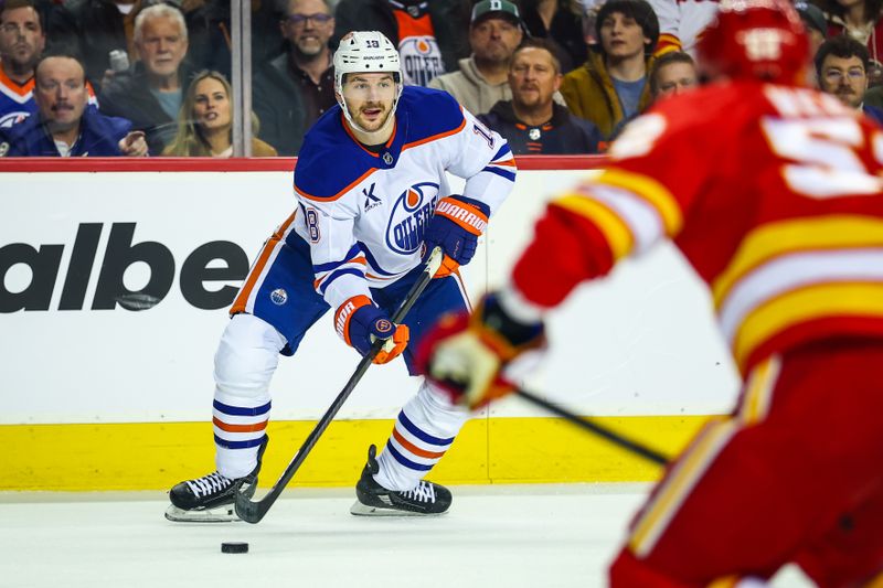 Dec 27, 2025; Calgary, Alberta, CAN; Edmonton Oilers left wing Zach Hyman (18) controls the puck against the Calgary Flames during the first period at Scotiabank Saddledome. Mandatory Credit: Sergei Belski-Imagn Images