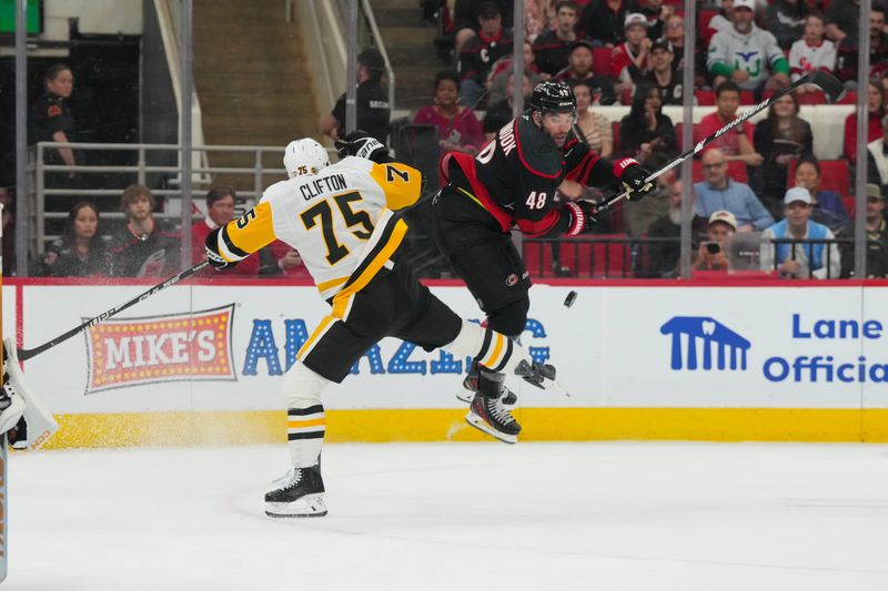 Mar 10, 2026; Raleigh, North Carolina, USA;  Pittsburgh Penguins defenseman Connor Clifton (75) goes to check Carolina Hurricanes left wing Jordan Martinook (48) during the first period at Lenovo Center. Mandatory Credit: James Guillory-Imagn Images