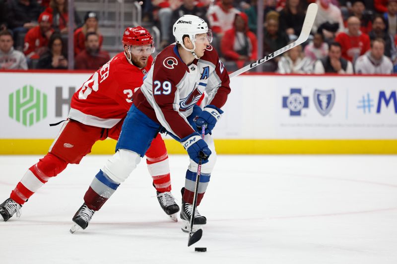 Feb 22, 2024; Detroit, Michigan, USA;  Colorado Avalanche center Nathan MacKinnon (29) skates with the puck while chased by Detroit Red Wings right wing Christian Fischer (36) in the second period at Little Caesars Arena. Mandatory Credit: Rick Osentoski-USA TODAY Sports