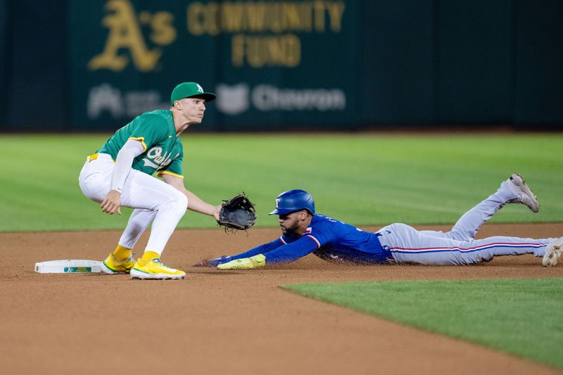 Sep 24, 2024; Oakland, California, USA; Texas Rangers center fielder Leody Taveras (3) steals second base against Oakland Athletics outfielder Daz Cameron (28) during the fourth inning at Oakland-Alameda County Coliseum. Mandatory Credit: Neville E. Guard-Imagn Images