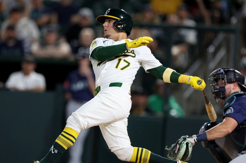 May 5, 2025; West Sacramento, California, USA; Athletics second baseman Luis Urias (17) hits a single against the Seattle Mariners during the fourth inning  at Sutter Health Park. Mandatory Credit: Dennis Lee-Imagn Images